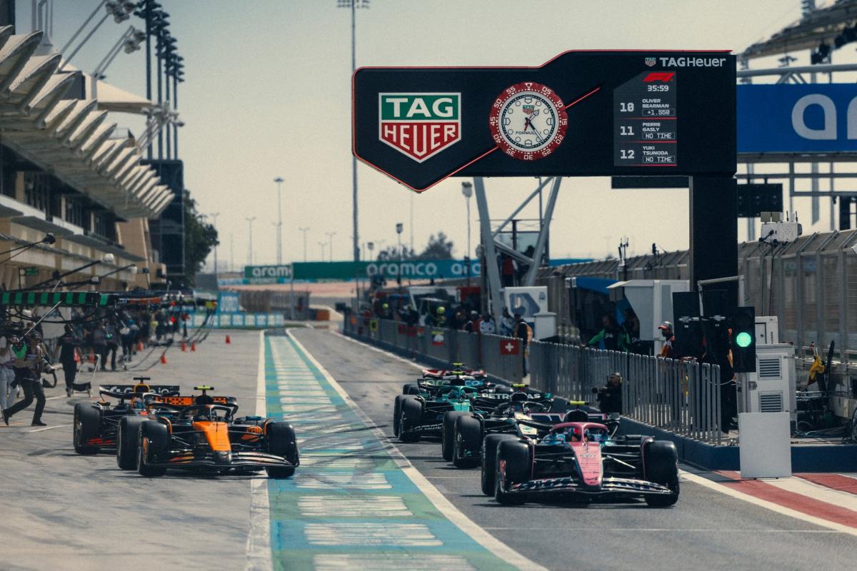 Pit lane de Formule 1 avec l'horloge Tag Heuer dominant les stands