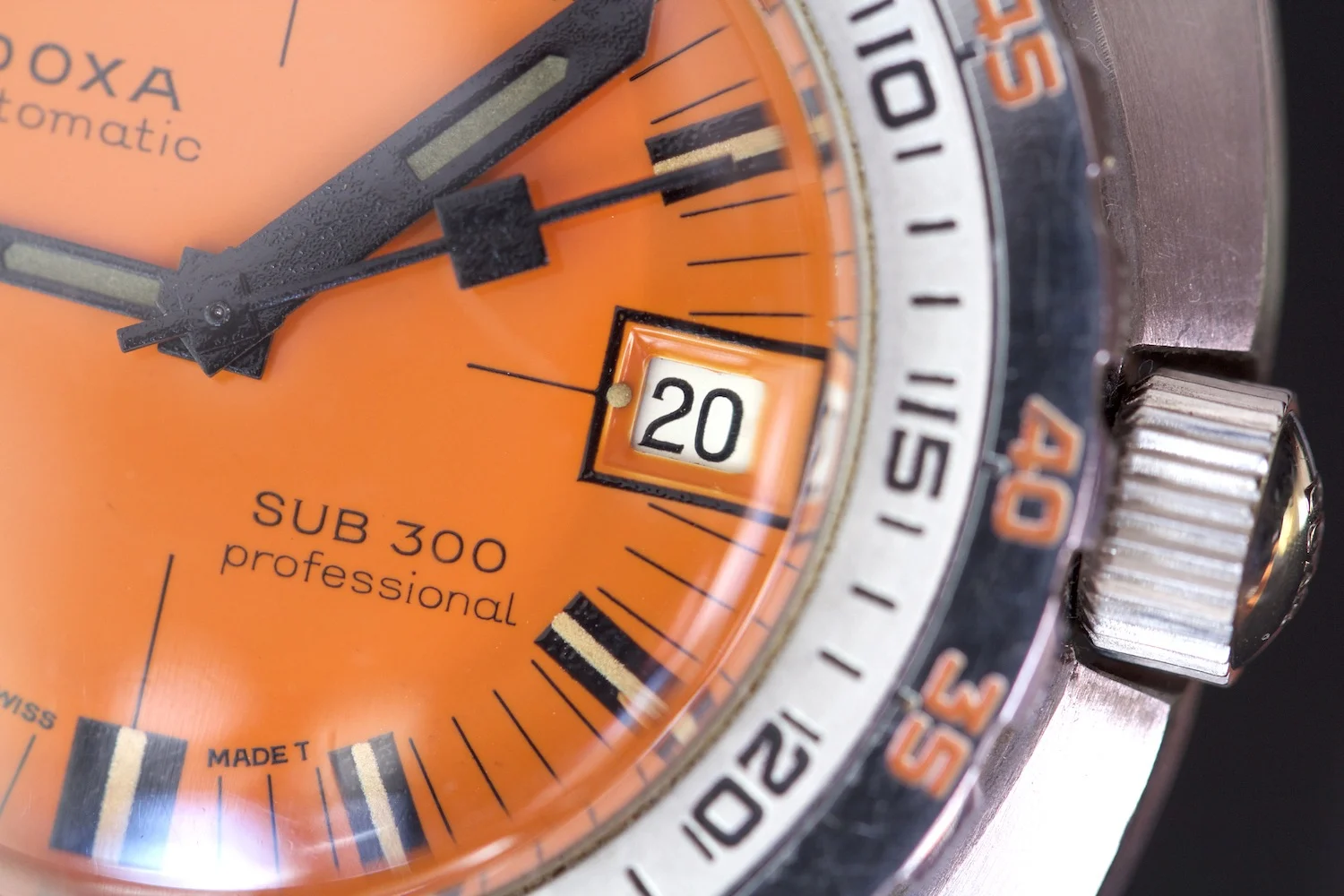 Close-up van de oranje wijzerplaat van de Doxa Sub 300, ontworpen voor onmiddellijke afleesbaarheid onder water.