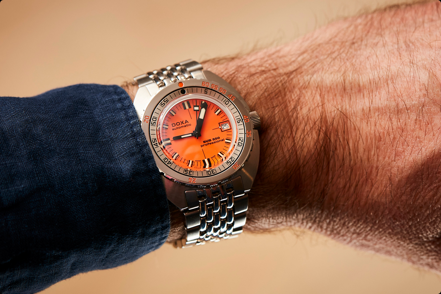 Oranje Doxa Sub 300 om de pols, bewijs dat het gereedschapshorloge ook buiten het water een onmiddellijk herkenbare aanwezigheid heeft opgelegd.